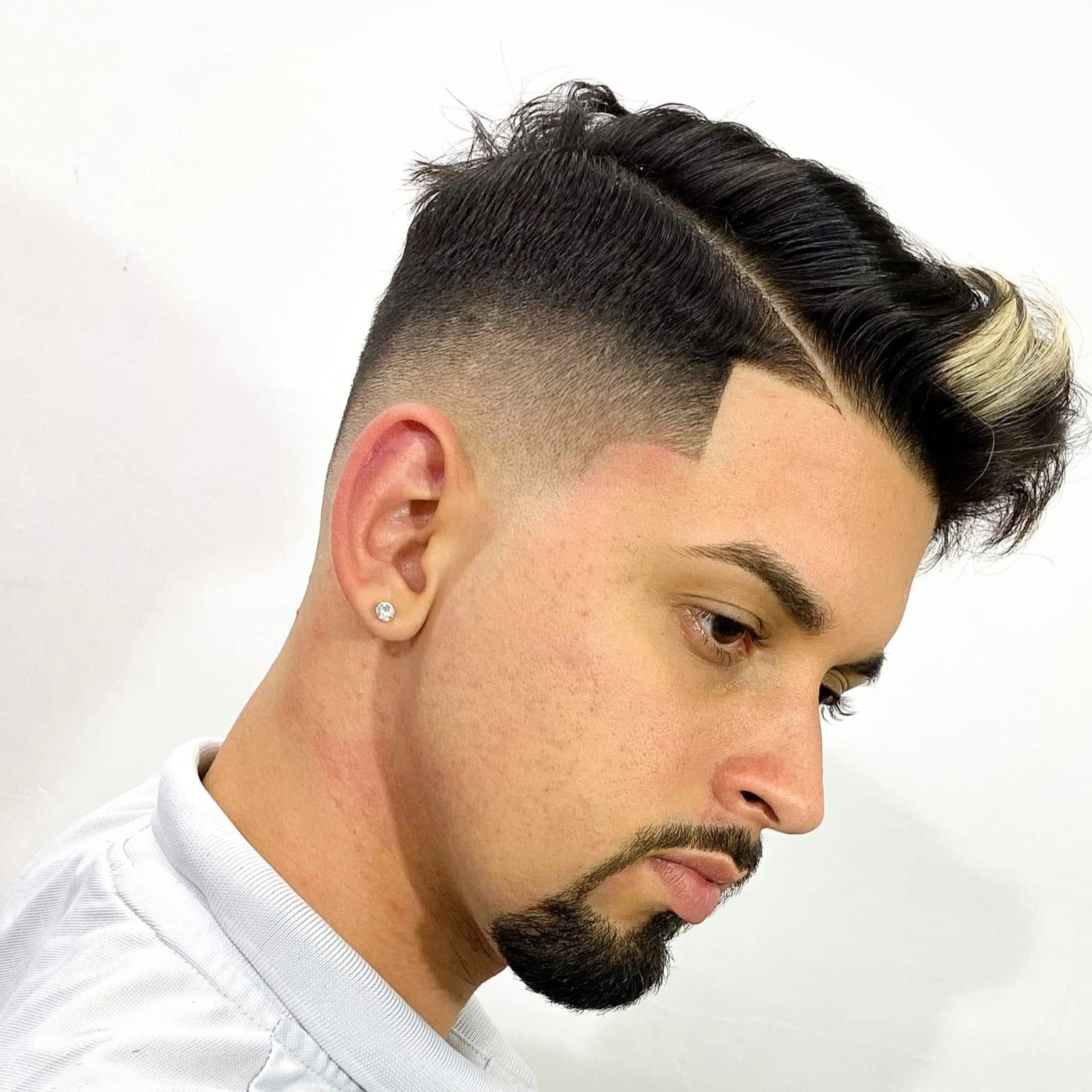 Risco lateral com mechas loiras e degradê alto